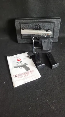 Ruger SR9 semi-automatic pistol set, featuring a stainless steel slide and black polymer frame, displayed with two magazines, original...