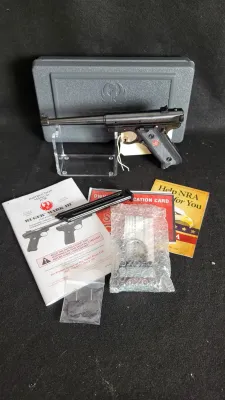 Ruger Mark III autoloading pistol in blued finish, displayed with its original hard case, magazine, instruction manual, and accessories.