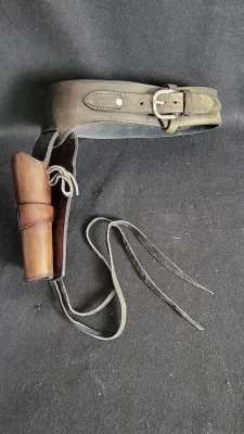Vintage Western-style leather gun belt and drop holster rig with silver-tone metal buckle and leg ties.
