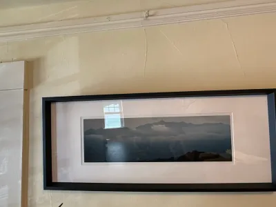 Sale Photo Thumbnail #226: Panoramic landscape photograph depicting misty mountains, presented in a black modern frame with white matting.