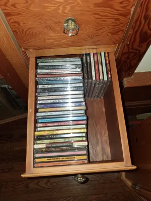 Sale Photo Thumbnail #86: Wooden desk drawer filled with a collection of assorted music compact discs in jewel cases, including artists like Johnny Otis, Luther Vandross, and Stevie Wonder.