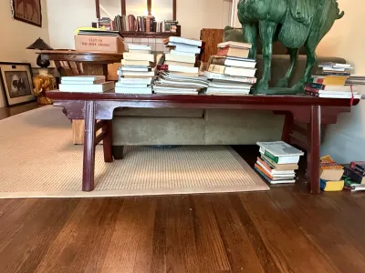 Sale Photo Thumbnail #213: Asian-style mahogany altar coffee table stacked with various books, displayed alongside a large green glazed ceramic Tang dynasty style horse statue.