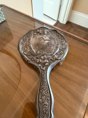 Sale Photo Thumbnail #246: Vintage Art Nouveau style silver-tone hand mirror featuring ornate floral relief work on the back and handle.