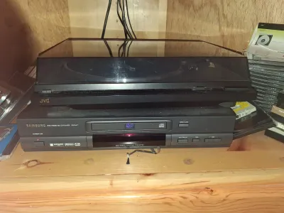 Sale Photo Thumbnail #103: Stacked vintage audio-visual electronics featuring a black JVC auto-return turntable sitting atop a Samsung DVD-611 player.