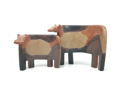 Sale Photo Thumbnail #62: Pair of vintage Mara Peru hand-carved stone cow figurines featuring a stylized, geometric design in earth tones.