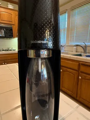 Sale Photo Thumbnail #459: Black SodaStream Fizzi sparkling water maker with a reusable carbonating bottle, shown in clean, gently used condition.