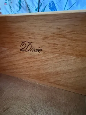 Sale Photo Thumbnail #397: Close-up detail of a Dixie Furniture brand maker's mark stamped inside a wooden drawer.