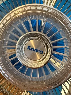 Sale Photo Thumbnail #324: Vintage Galaxy electric fan center emblem featuring a clear clear plastic and metallic center cap with blue fan blades behind a wire cage.