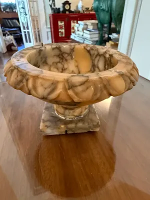 Sale Photo Thumbnail #285: Carved alabaster or onyx urn-style bowl on a square pedestal base, featuring natural dark veining and a gadrooned rim.