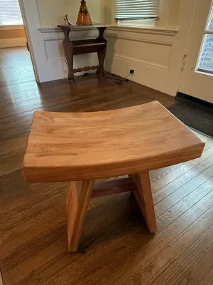 Sale Photo Thumbnail #171: Solid wood saddle-seat bench or low stool with a curved top and splayed legs.