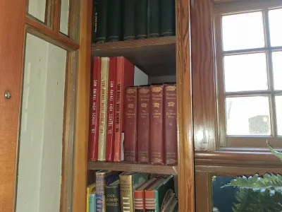 Sale Photo Thumbnail #89: A collection of vintage books on wooden shelves, including San Rafael High School yearbooks from 1963 to 1966 and volume sets of The Children's Hour.