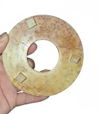 Sale Photo Thumbnail #59: Hand-carved Chinese jade or stone bi disc with raised square bosses along the surface, showing natural calcification and weathered patina.