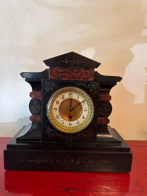 Sale Photo Thumbnail #120: Antique Victorian mantle clock featuring a black case with faux-marbled red accents and engraved gilt details.