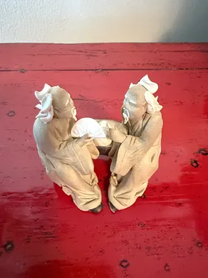 Sale Photo Thumbnail #152: Vintage Mudman ceramic figurine depicting two seated elders conversing, featuring white glazed hair and fan accents.