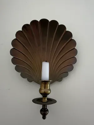 Sale Photo Thumbnail #417: Vintage brass wall sconce featuring a scallop shell reflective backplate and single candle holder with a white taper candle.