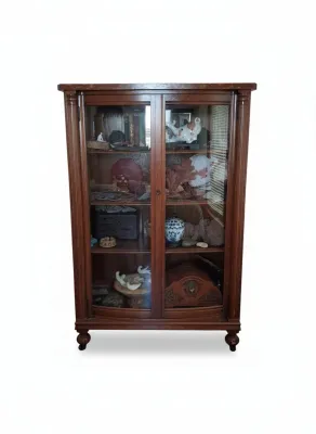 Sale Photo Thumbnail #16: Traditional dark wood display cabinet with glass doors, fluted side columns, and bun feet, filled with various Asian collectibles and decor items.