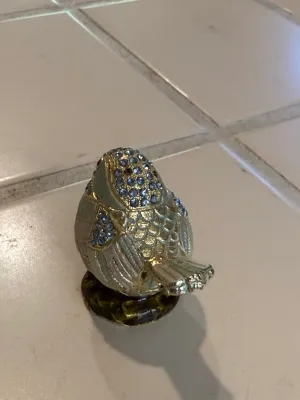 Sale Photo Thumbnail #485: Jeweled bird trinket box, featuring blue rhinestone accents and gold-tone detailing on a pedestal base.