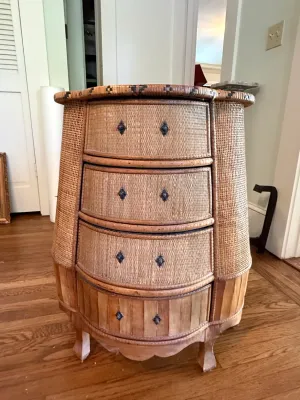 Sale Photo Thumbnail #300: Vintage woven wicker and wood bow-front chest of drawers featuring dark metal diamond-shaped knobs and a scalloped apron.
