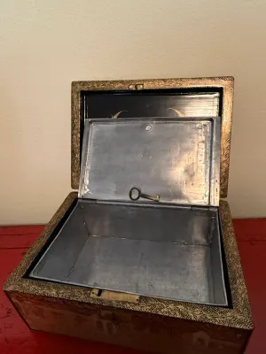 Sale Photo Thumbnail #128: Antique Asian black lacquer tea caddy box with gold gilt decorations, featuring a metal-lined interior compartment and small key.