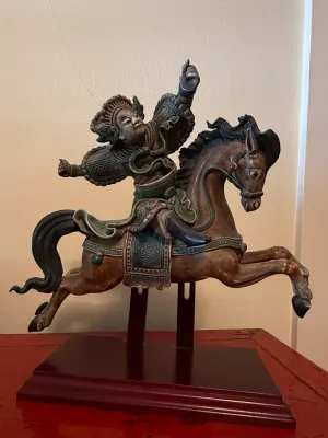Sale Photo Thumbnail #151: Hand-carved and polychrome painted Asian warrior on horseback statue, mounted on a dark wooden display stand.