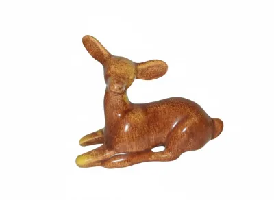 Sale Photo Thumbnail #64: Vintage glazed ceramic deer figurine in a resting posture, featuring a rich brown and yellow mottling, likely mid-century.