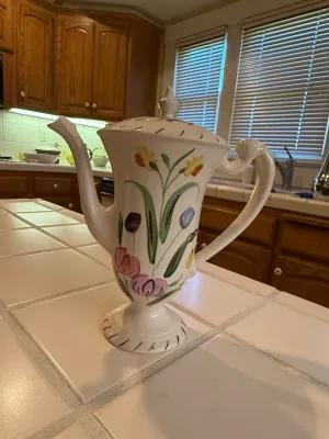 Sale Photo Thumbnail #477: Vintage hand-painted ceramic coffeepot with lid, featuring colorful floral motifs on a white background.