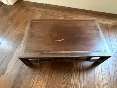 Sale Photo Thumbnail #210: Low Asian-style wooden coffee table featuring openwork apron details and visible surface scratches.