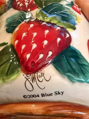 Sale Photo Thumbnail #480: Close-up of a glazed ceramic strawberry-themed piece signed by J. McCall for Blue Sky, copyright 2004.