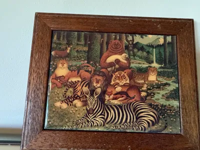 Sale Photo Thumbnail #390: Framed ceramic tile featuring a colorful peaceable kingdom animal illustration in a dark oak frame.