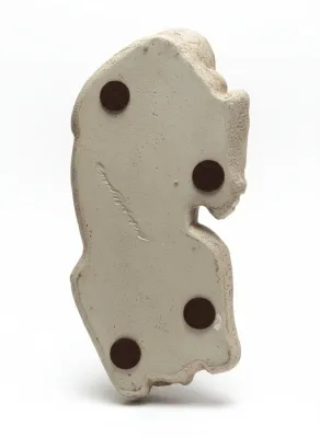 Sale Photo Thumbnail #43: Underside of an incised ceramic or plaster sculpture showing four brown felt protective pads and a faint artist signature.