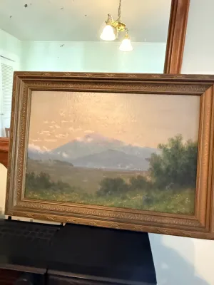 Sale Photo Thumbnail #353: Framed oil painting depicting a hazy mountain landscape scene, set in an ornate molded wood frame.