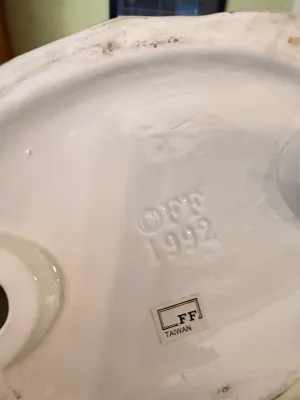 Sale Photo Thumbnail #440: Underside of a Fitz and Floyd ceramic item showing an embossed copyright mark from 1992 and an original maker's sticker reading "FF TAIWAN".