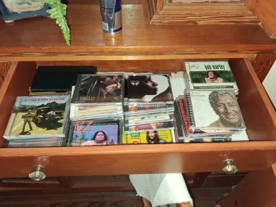 Sale Photo Thumbnail #85: Open wooden drawer filled with music CDs in jewel cases, including albums by Bob Marley, JJ Cale & Eric Clapton, Tony Bennett, and George Michael.