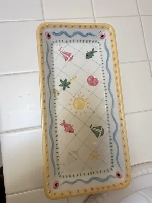 Sale Photo Thumbnail #401: Hand-painted nautical rectangular ceramic serving tray with sailboat, palm tree, and fish motifs.