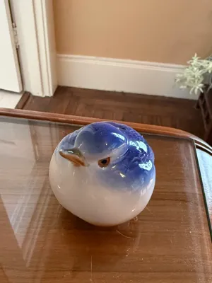 Sale Photo Thumbnail #259: Vintage rounded blue and white ceramic bird figurine displayed on a glass-top table.