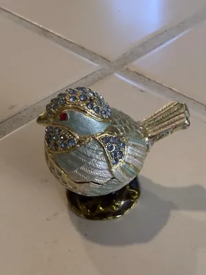 Sale Photo Thumbnail #483: Miniature jeweled bird trinket box adorned with blue crystals, gold-tone accents, and a red crystal eye.