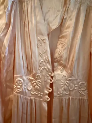 Sale Photo Thumbnail #338: Vintage pale pink satin nightgown or negligee featuring intricate raised floral embroidery and loop button closures along the fitted waist.