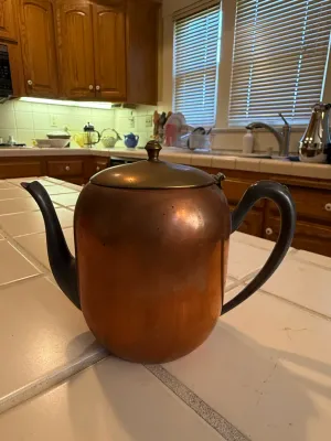 Sale Photo Thumbnail #453: Vintage copper teapot with brass lid accent and black metal handle and spout, showing a natural warm patina.
