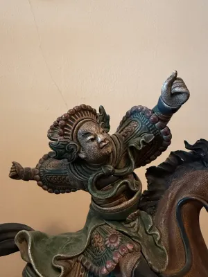 Sale Photo Thumbnail #148: Intricately detailed ceramic or pottery sculpture depicting a dynamic Chinese warrior on horseback with textured armor and a raised hand.