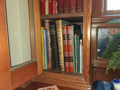 Sale Photo Thumbnail #87: Collection of vintage books displayed inside a wooden cabinet shelf, including titles from Childcraft, American Heritage, and Our Wonder World.