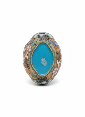 Sale Photo Thumbnail #65: Vintage Chinese cloisonné enamel piece featuring intricate floral patterns around a central bright blue cabochon, showing minor surface wear.