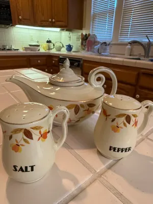 Sale Photo Thumbnail #444: Vintage ceramic teapot and matching salt and pepper shakers featuring a autumn floral motif with gold trim.
