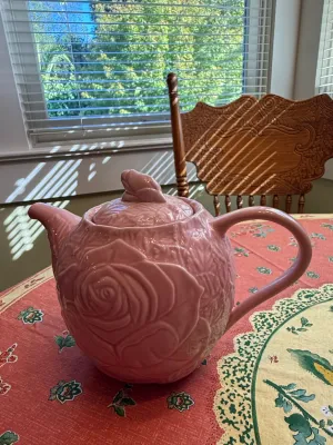 Sale Photo Thumbnail #471: Pink ceramic teapot featuring a raised rose design on the body and a rosebud finial lid.