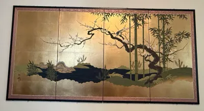 Sale Photo Thumbnail #222: Four-panel Japanese folding screen art featuring gold leaf ground, flowering plum branch, bamboo stalks, and a stylized landscape mounted in a black frame.