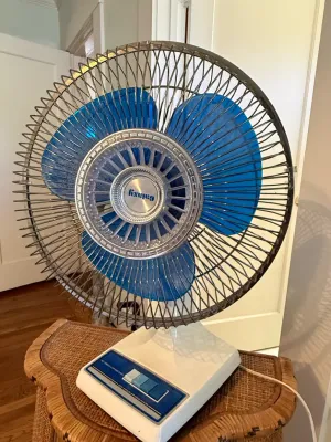 Sale Photo Thumbnail #327: Vintage Galaxy oscillating desk fan with translucent blue blades and a white plastic base, circa late 1970s to 1980s.