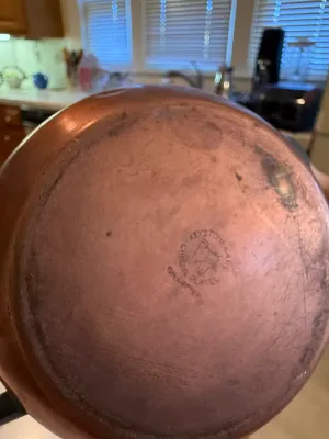 Sale Photo Thumbnail #451: Bottom stamp of a vintage Keystoneware copper pot, showing wear and patina from age and use.