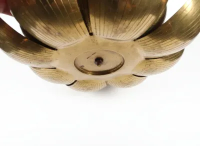 Sale Photo Thumbnail #17: Underside detail of a mid-century vintage brass lotus flower candlestick holder, showing the bolted central base and textured petal design.
