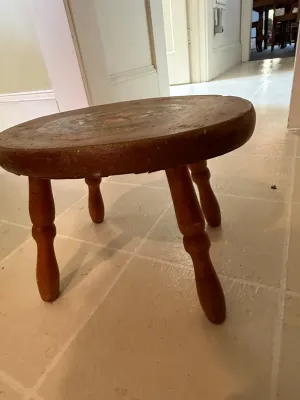 Sale Photo Thumbnail #426: Rustic round wooden milking stool with turned legs and a distressed finish.