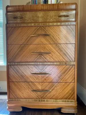 Sale Photo Thumbnail #206: Art Deco waterfall tallboy dresser, featuring book-matched chevron wood veneers and sculpted metal drawer pulls, circa 1930s-1940s.