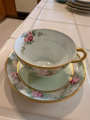 Sale Photo Thumbnail #448: Vintage fine china teacup and saucer set featuring hand-painted pink roses, light green trim, and gilded rims.